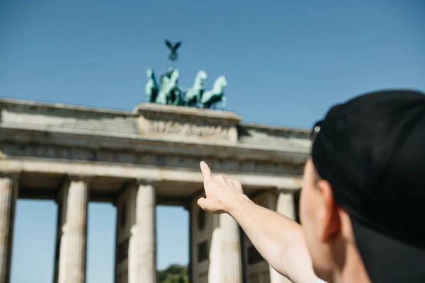 Turistické nebo chlap ukazuje ruku na Braniborská brána v Berlíně — Stock fotografie