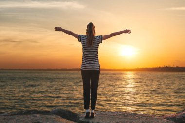 Yalnızlık bir kız Türkiye'de Istanbul'da Boğaz'ın kıyısında duruyor ve ellerini yukarı yükseltir