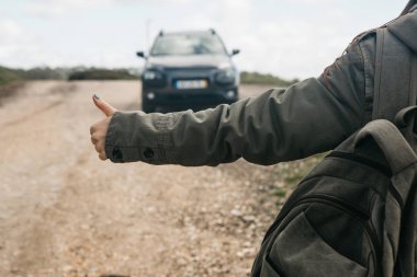 Otostop bir sırt çantası ile bir turist kızın yakın çekim.