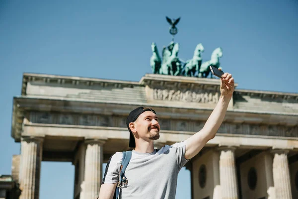 Tourist guy taking a selfie or taking pictures of sights