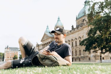 Bir öğrenci çimenlerin üzerinde yatıyor ve müzik dinliyor.