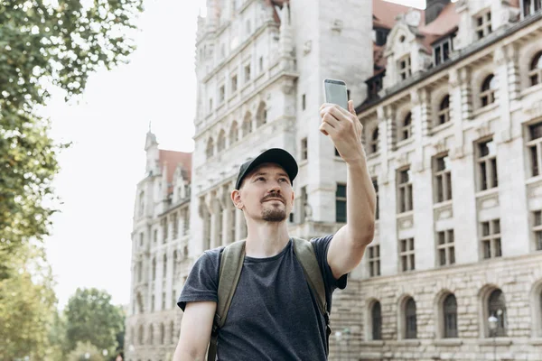 Egy fiatal férfi vagy turisztikai vagy diák használ egy mozgatható telefon. — Stock Fotó
