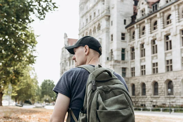 A young man or tourist or student with a backpack looks at the sights in Leipzig in Germany — Stock Photo, Image