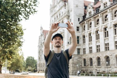Bir genç adam veya turist veya öğrenci bir cep telefonu kullanır.