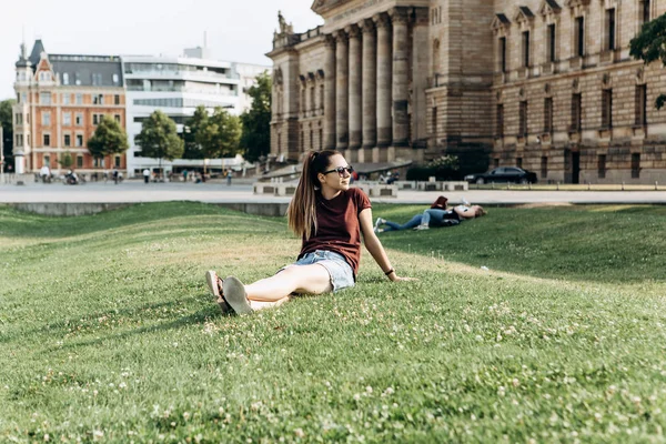 Krásná mladá dívka na trávě na ulici v Lipsku v Německu. — Stock fotografie