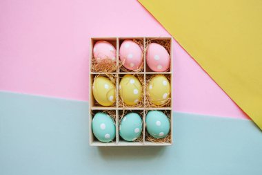 Hediye veya tatil kutusu veya kapsayıcı renkli Paskalya ile parlak bir çok renkli arka plan üzerinde yumurta.