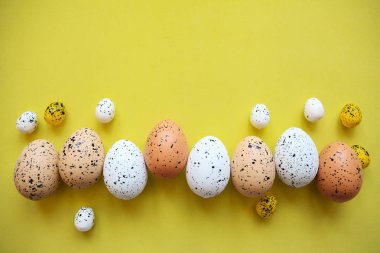Sarı bir arka plan üzerinde renkli yumurta kümesi. Festival Paskalya kavramı.
