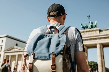 Bir turist veya Almanya'da Berlin Brandenburg Gate yakınındaki bir sırt çantası ile bir öğrenci.