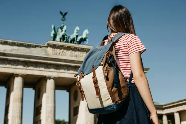 Een toerist of een student met een rugzak in de buurt van de Brandenburger Tor in Berlijn in Duitsland. — Stockfoto