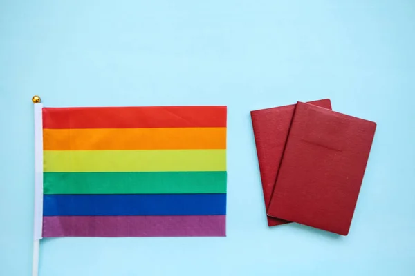 La bandera multicolor es una bandera de color arco iris o LGBT junto a un pasaporte. Migración LGBT — Foto de Stock