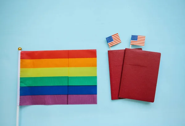 La bandera multicolor es una bandera de color arco iris o LGBT junto a un pasaporte. Migración LGBT — Foto de Stock