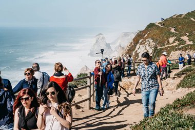 Portekiz. Bir grup insanlar ya da turist manzaraları hayranlıkla ve fotoğraf çekmek ve selfies Cape Roca'da almak.