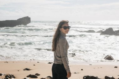 Güneş gözlüğü Atlantik Okyanusu kıyısında güzel bir genç kız portresi