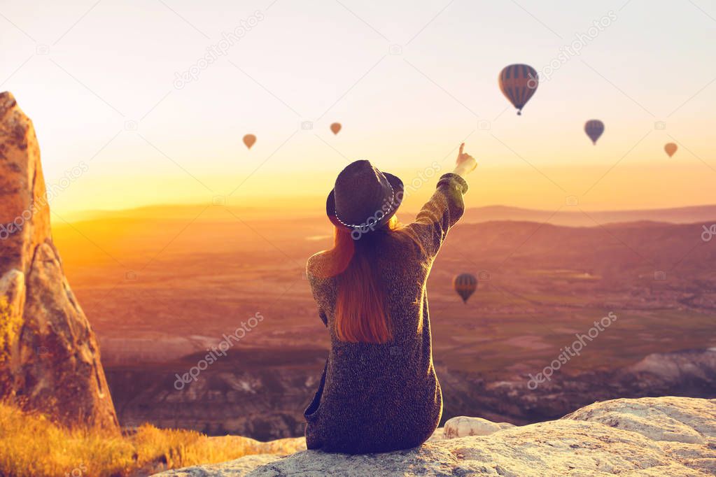 Woman admires flying balloons