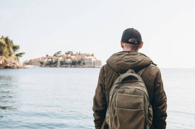 Denize yakın bir sırt çantası ile Turist