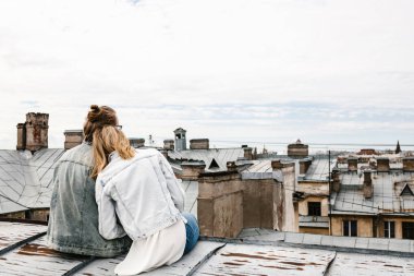 Çatıda oturan genç çift.