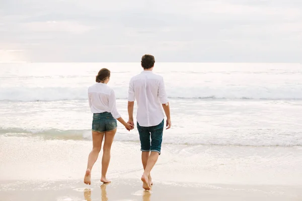 Un hombre y una mujer tomados de la mano y caminando — Foto de Stock