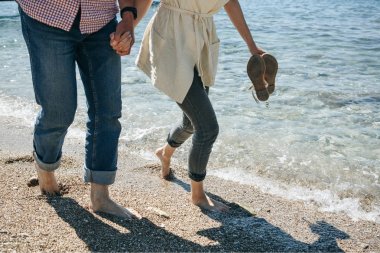 İnsanlar kıyıboyunca yürürler.