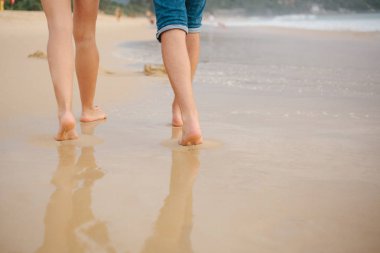 İnsanlar kıyıboyunca yürürler.