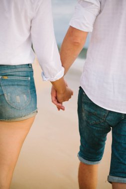 Bir erkek ve kadın el ele tutuşup yürürler.