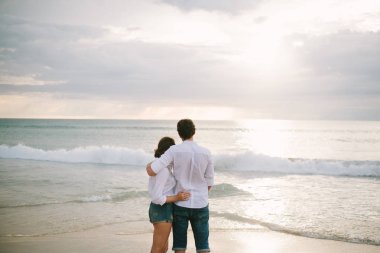 Bir erkek bir kadına sarılır..