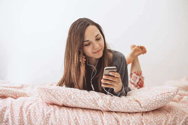 Una chica escucha música o un podcast . — Foto de Stock