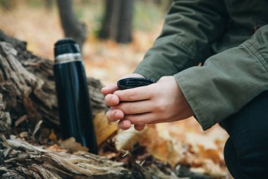 Elinde termos olan kişi.