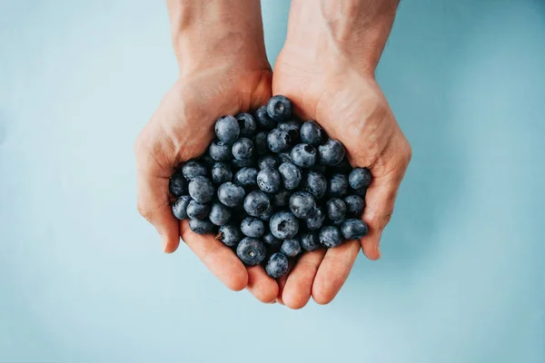 Man holds blueberries in hands