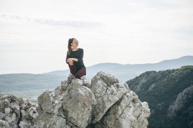 Dağın tepesinde oturan kız