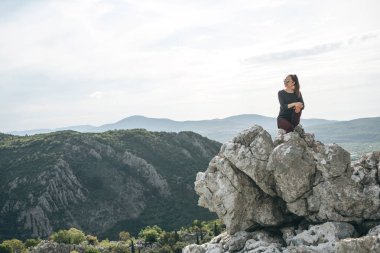 Dağın tepesinde oturan kız