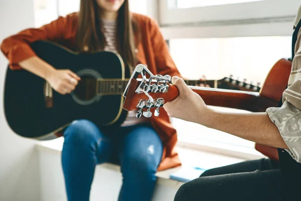 Learning to play the guitar. The teacher explains to the student the basics of playing the guitar. Individual home schooling or extracurricular lessons.