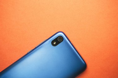 Portakal rengi arka planda kameralı cep telefonu ya da cep telefonu