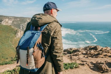 Portekiz 'in güneyindeki doğal manzaranın arka planında sırt çantalı bir turist..