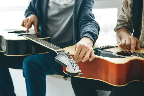 Learning to play the guitar. The teacher helps the student tune the guitar and explains the basics of playing the guitar. Individual home schooling or extracurricular lessons.
