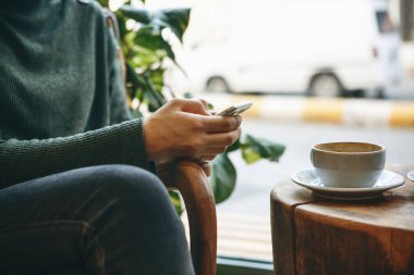 Cep telefonu ve kahvesi olan kız..