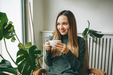 Kız sıcak bir içki içiyor.