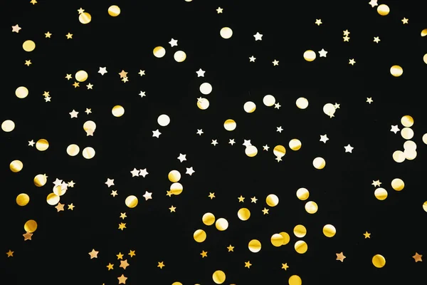 Gold confetti on a black background — Stock Photo, Image