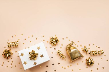 Hediye kutusu ve siyah ya da koyu arkaplanda çeşitli altın eşyalar. Kutlamalı kavramsal Noel ya da yeni yıl geçmişi ya da Kara Cuma indirimi. Yukarıdaki alanı kopyala.