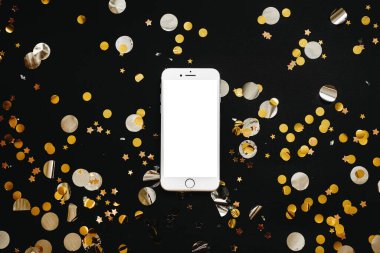 Boş beyaz ekranlı cep telefonu ya da boşluğu kopyalamak ya da altın konfetiyle siyah arkaplanı kaplamak. Tatil indirimi kavramsal arka plan.