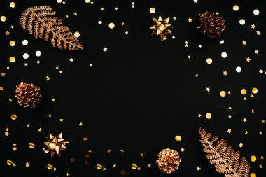 Koyu veya siyah arka planda çeşitli şenlik eşyaları ve altın rengi süslemeler. Ortada metin ya da kopyalama alanı var. Noel ya da Yeni Yıl konsepti.