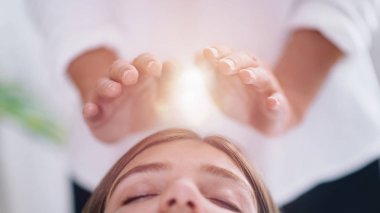 Görüntü rahat genç kadının gözleri kapalı ve Reiki şifa tedavi spa merkezi olan ile yalan kadar kapatın. Enerji şifa kavramı. 