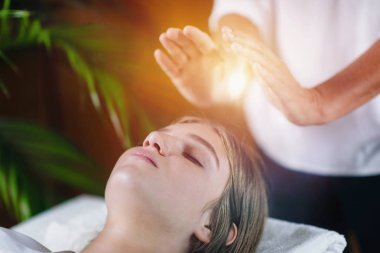Görüntü rahat genç kadının gözleri kapalı ve Reiki şifa tedavi spa merkezi olan ile yalan kadar kapatın. Enerji şifa kavramı. 