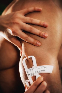 Triceps deri kıvrım kalınlığı (Halife) Erkek atlet kullanarak üzerinde vücut yağ ölçme.   