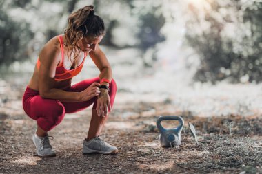 Açık egzersiz. Kadın atlet onun faaliyetlerini izlemek için fitness bant kullanarak