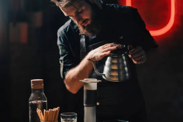 咖啡师将开水倒进空气压机咖啡机 带着纹身手臂的巴里斯塔身穿深色制服 — 图库照片