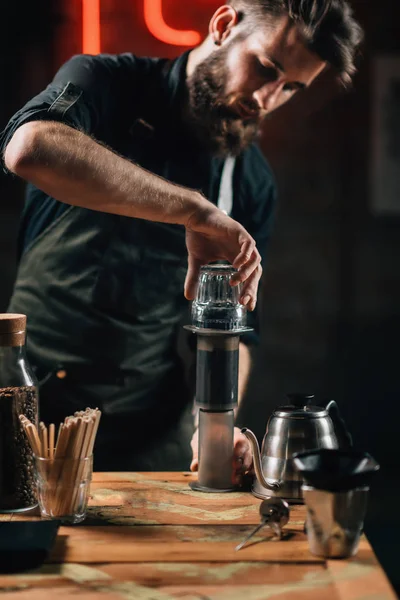 关闭咖啡师制作空气压榨咖啡的垂直图像 带着纹身手臂的巴里斯塔身穿深色制服 — 图库照片