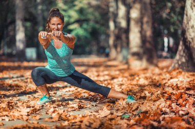 Kadın parkta, sonbaharda germe.