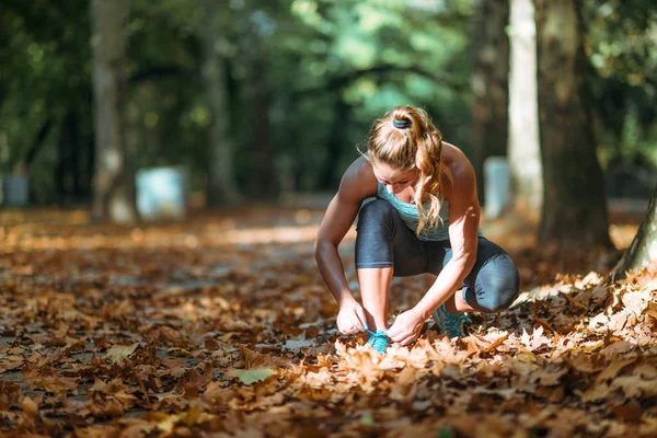 Frau Kniet Und Bindet Schuhe Park — Stockfoto