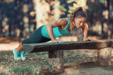 Kadının yapması Push ups parkında sonbahar Halk Parkı