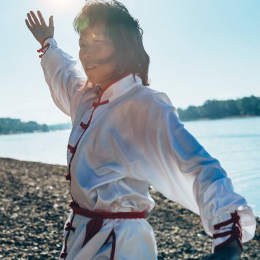 Geleneksel giyim Tai Chi göl kenarında pratik Asyalı kadın